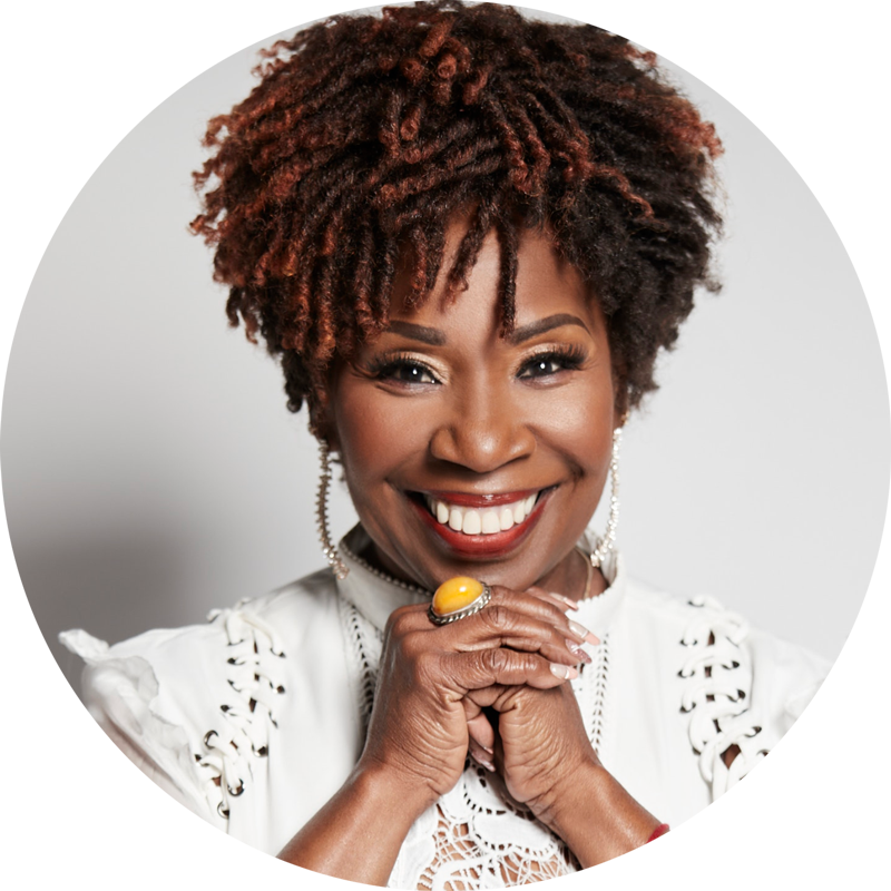 iya-circle Iyanla Vanzant smiling with hands folded under her chin