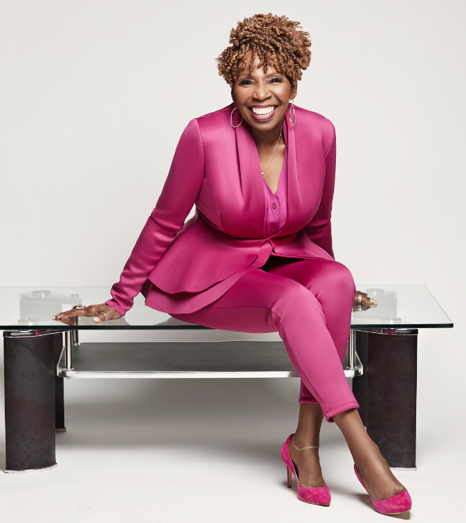 iyanla in pink seated Iyanla Vanzant sitting on a glass bench